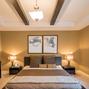 Beżowa sypialnia z belkami pod sufitem – elegancka aranżacja